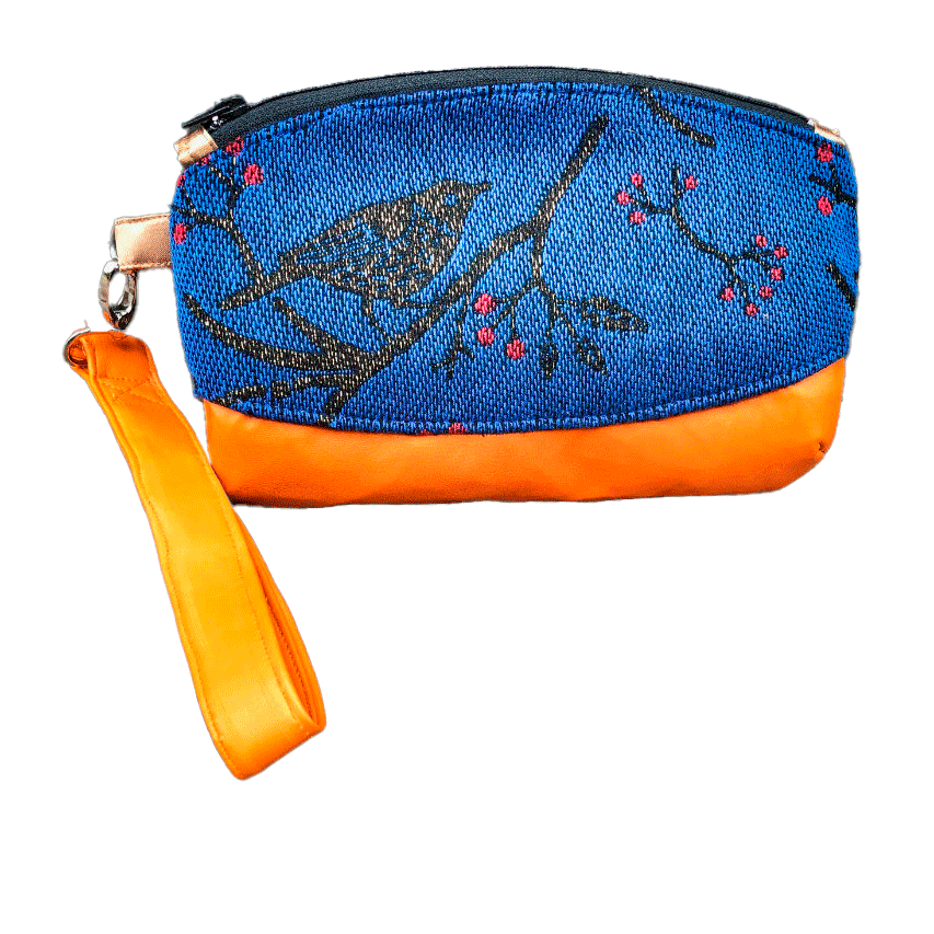Une petite pochette zippée cousue en cuir orange et une écharpe de portage bleu électrique, noir et rouge avec un motif d'oiseaux dans des branches'.