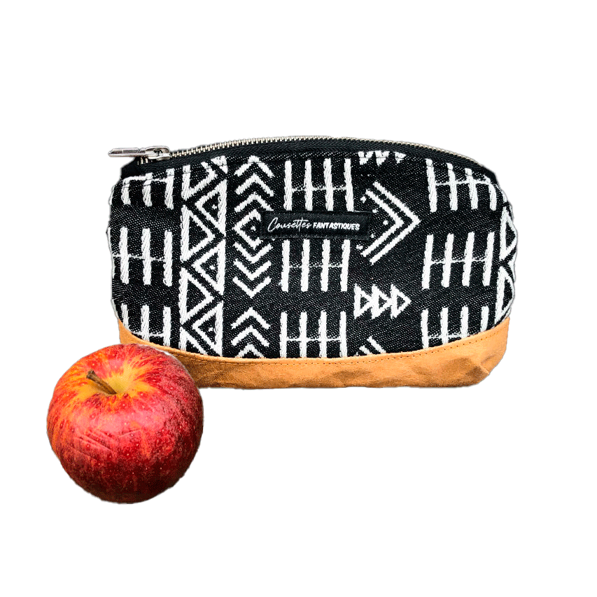Une petite pochette zippée fabriquée en papier lavable coloris caramel, une écharpe de portage à motifs géométriques en noir et blanc, et de la popeline grise.