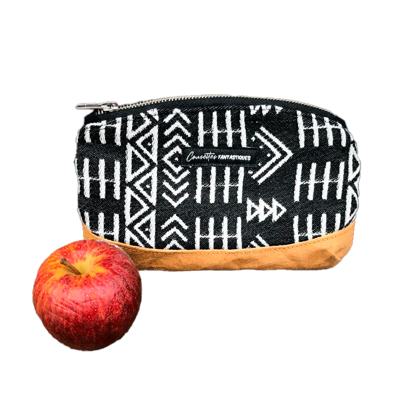 Une petite pochette zippée fabriquée en papier lavable coloris caramel, une écharpe de portage à motifs géométriques en noir et blanc, et de la popeline grise.