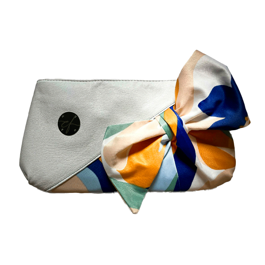 Une petite pochette zippée cousue en similicuir blanc et une écharpe colorée avec un design floral moderne et abstrait en blanc, bleu, sauge, beige et cannelle. À l'intérieur se trouve un popeline brillant de couleur sauge claire.