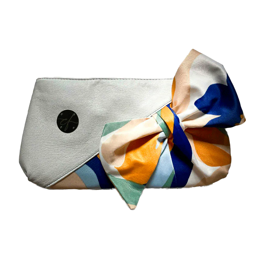 Une petite pochette zippée cousue en similicuir blanc et une écharpe colorée avec un design floral moderne et abstrait en blanc, bleu, sauge, beige et cannelle. À l'intérieur se trouve un popeline brillant de couleur sauge claire.