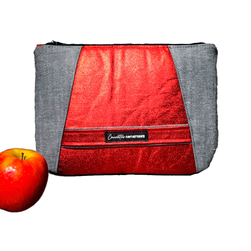Une pochette zippée cousue dans un denim bi-face gris et rouge métallisé, associé à de la soie rouge vif.