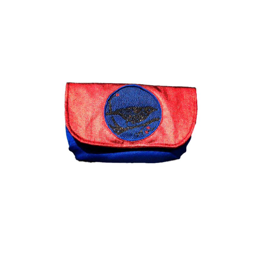 Une petite pochette à rabat cousue en toile bleue, denim enduit rouge métallisé et écharpe de portage au motif aviaire à paillettes, doublée de satin doré.