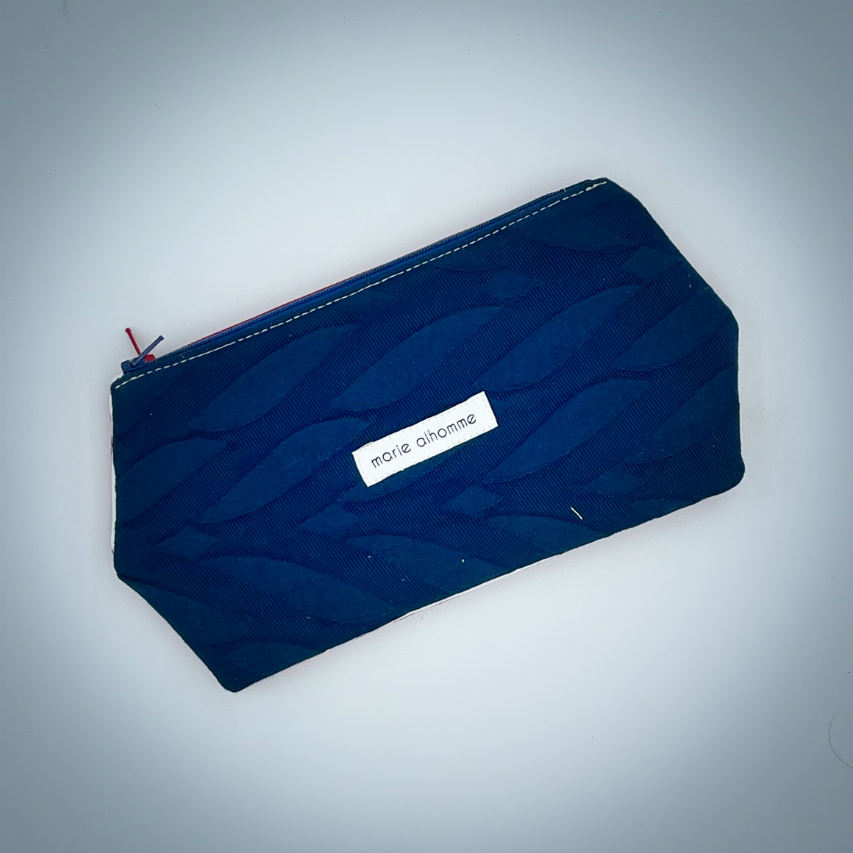 Une pochette zippée double cousue dans plusieurs coupons d'écharpe de portage (bleu et rouge) et simili blanc.