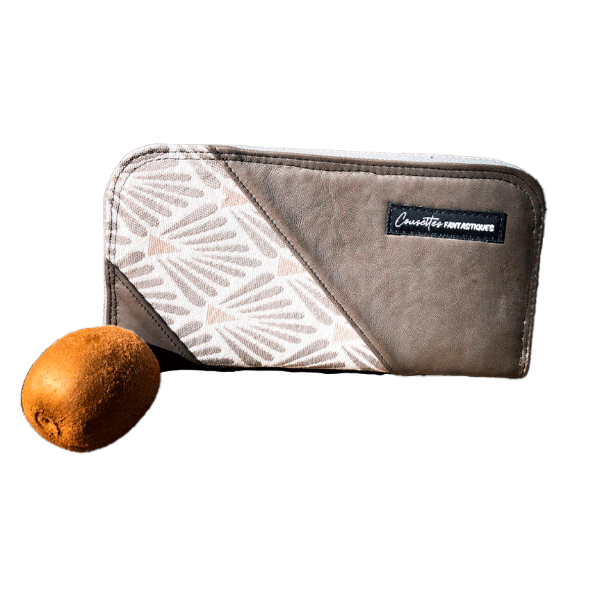 Un porte-cartes-et-monnaie zippé en cuir d'agneau gris, tissu d'ameublement et toile de lin brut.
