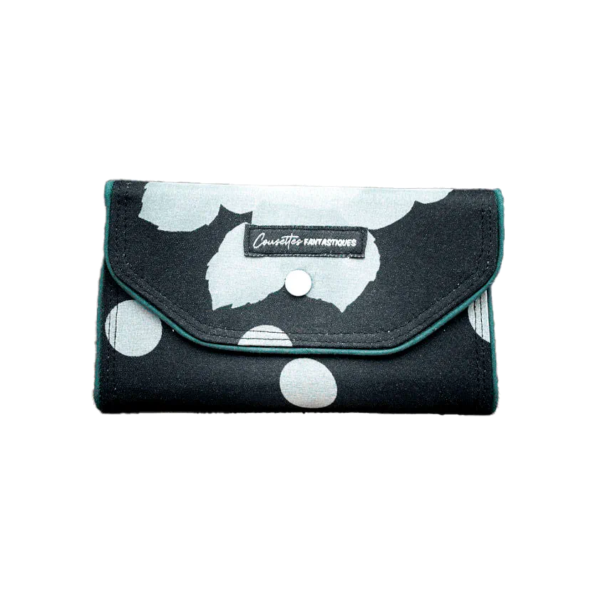 Un portefeuille fait de foulard de soie à fleurs noires et blanches à l'extérieur et de popeline noire à l'intérieur.