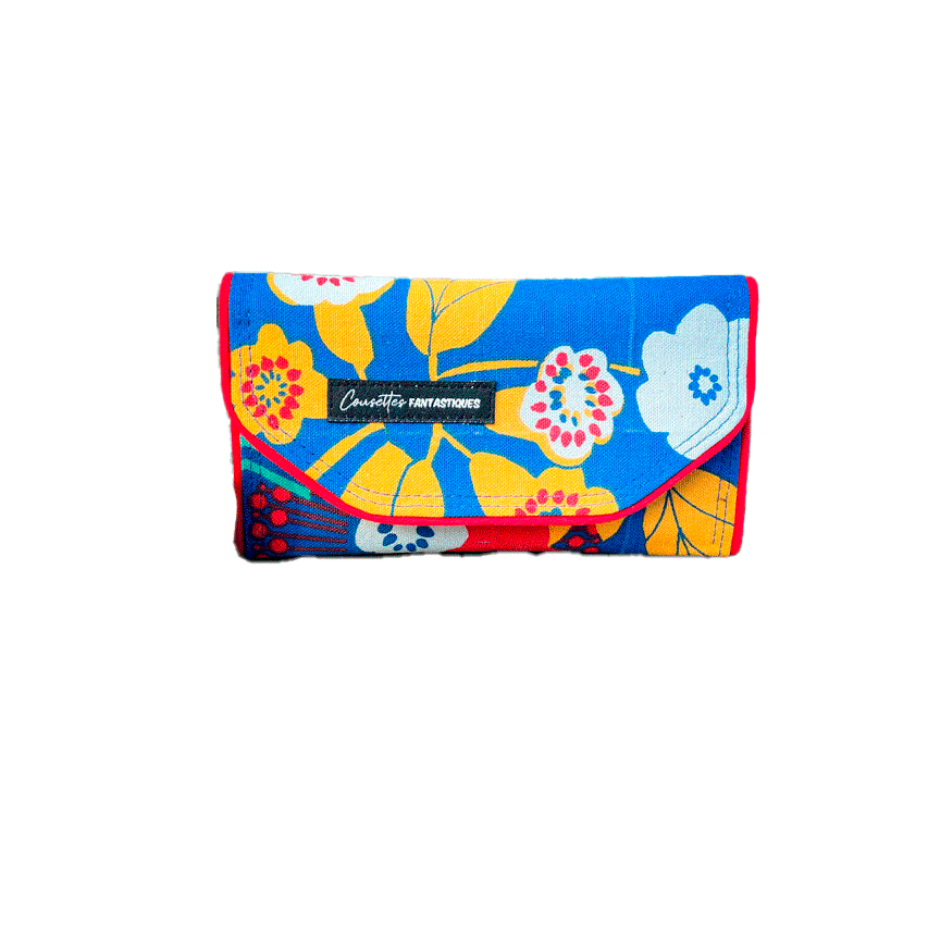 Un portefeuille fait en toile bleue roi à motifs floraux jaunes, blancs et rouges à l'extérieur et toiles unies jaune et rouge à l'intérieur.