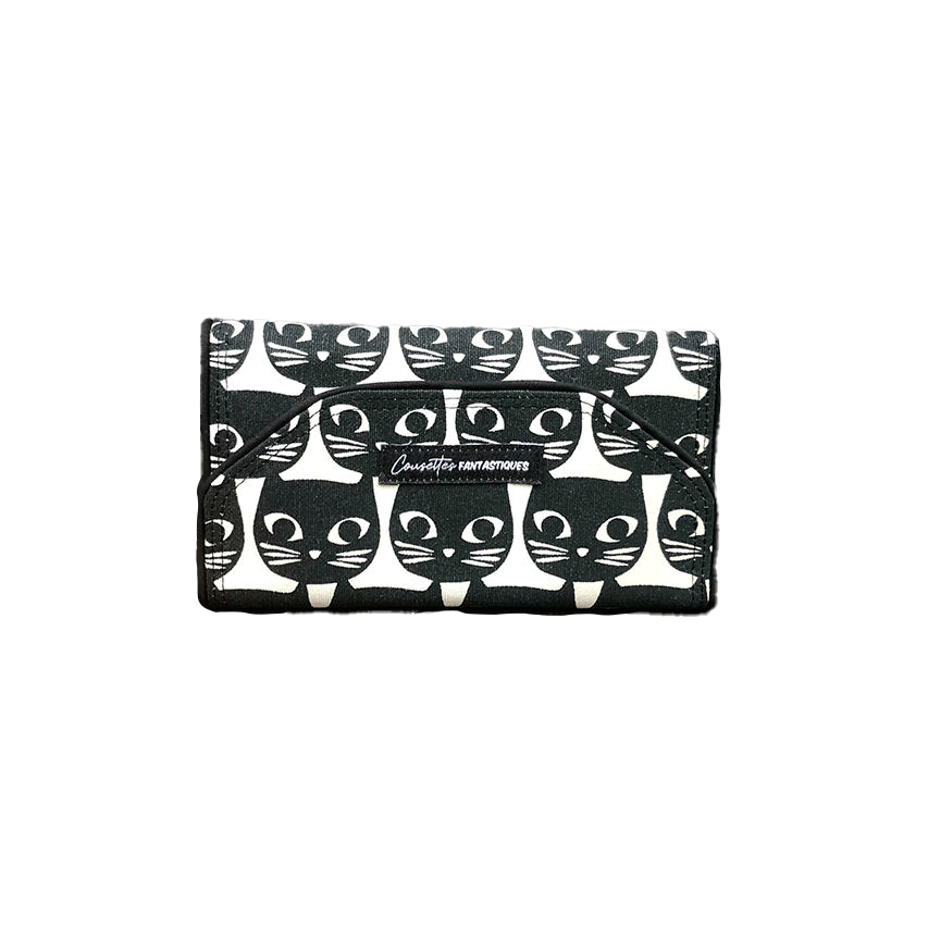 Un portefeuille fait de toile de coton noir et blanc à motif de têtes de chat à l'extérieur, et de popeline rose et de cretonne à motifs d'oiseaux à l'intérieur.