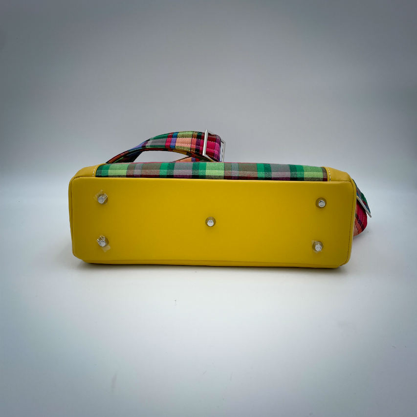 Un sac cartable constitué de cuir jaune et de toile de madras multicolore.