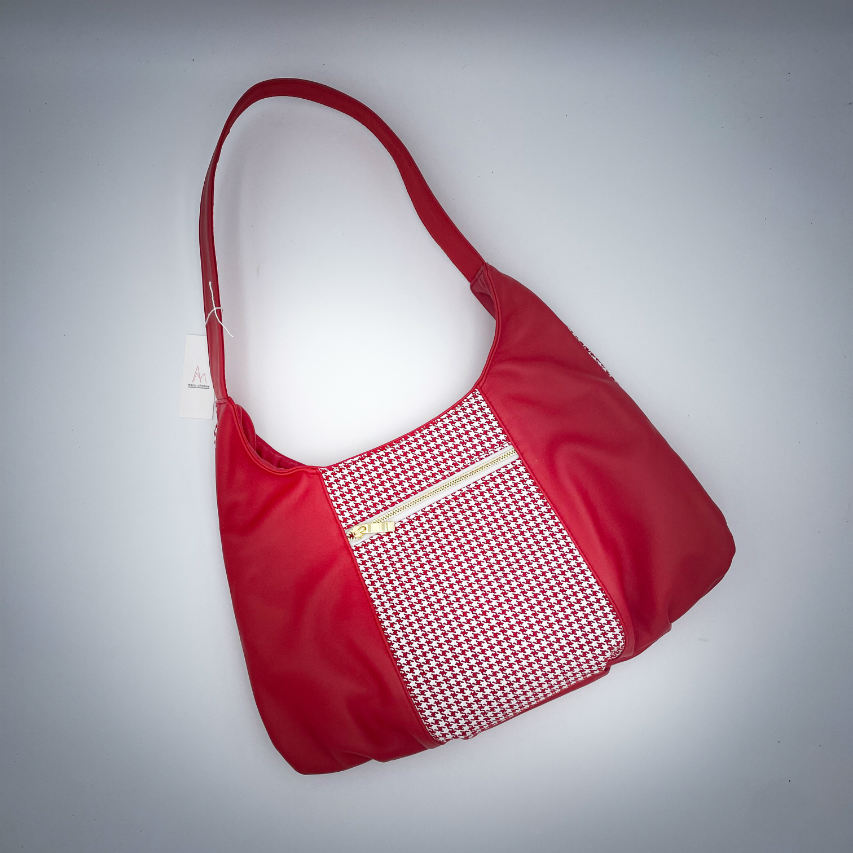 Un sac d'épaule fabriqué à partir d'un cuir rouge et d'un cuir rouge imprimée pied de poule blanc, avec une doublure rouge siglée Sonia Rykiel.