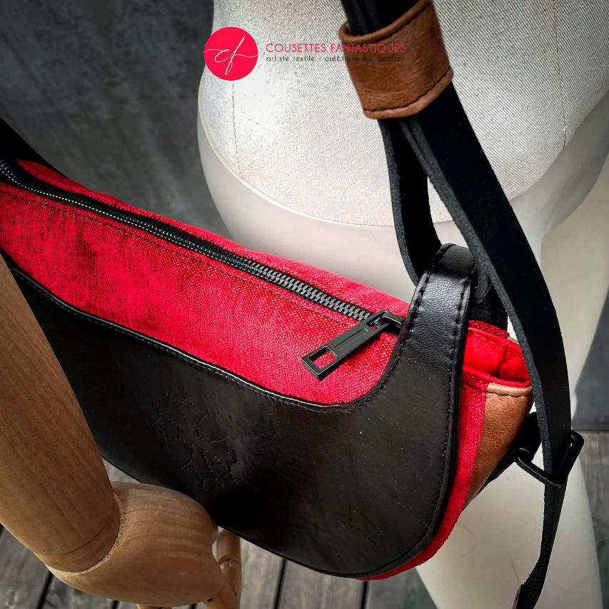 A shoulder bag made of black and caramel leathers, red and black velvet upholstery fabric, and red and black satins.