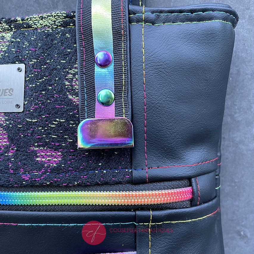 Two-tone/two-material handles, luxury rainbow-colored hardware, velvety upcycled synthetic leather, and a playful babywearing fabric coupon with a whimsical pattern.