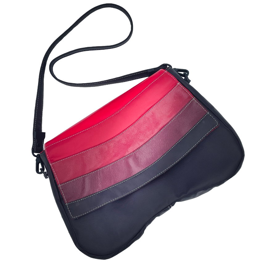 Un sac d'épaule composé de cuirs de différentes teintes de rouge, un marron et une doublure rouge.