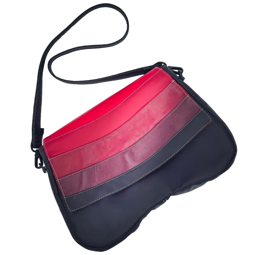 Un sac d'épaule composé de cuirs de différentes teintes de rouge, un marron et une doublure rouge.
