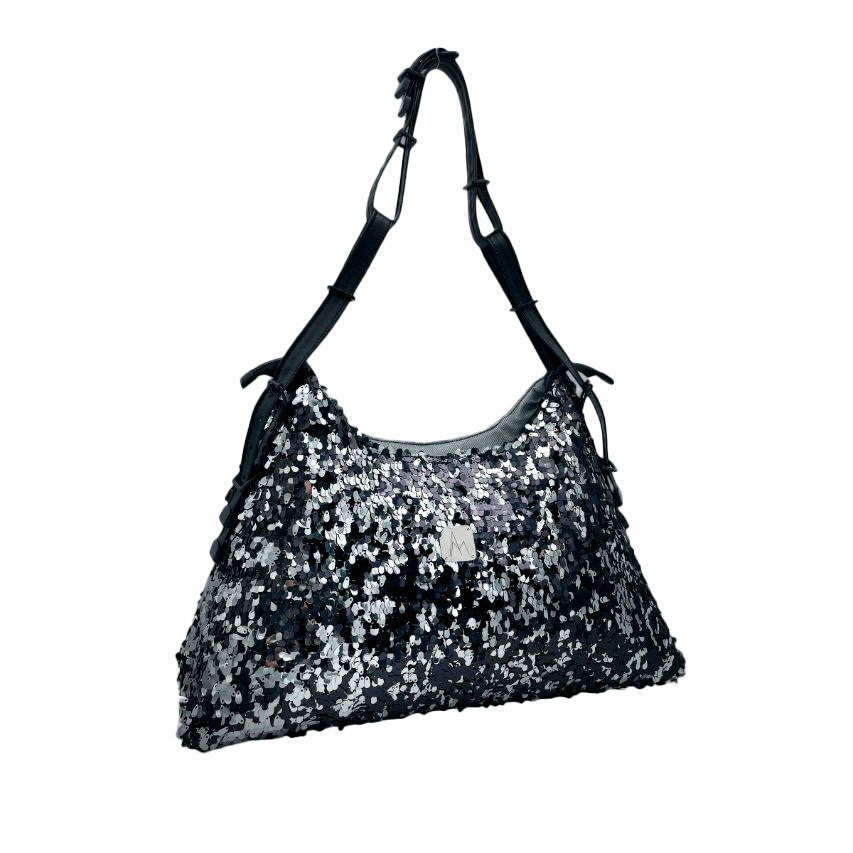 Un grand sac d'épaule fabriqué à partir d'un tissu à sequins noirs et argents, un denim couture gris et un simili fin noir.