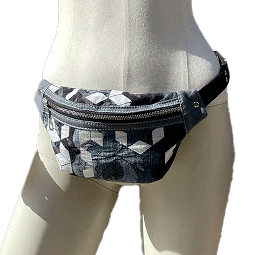 Une banane en tissu d'écharpe de portage aux tons gris, blanc et bleu avec un motif floral et géométrique et en denim gris.
