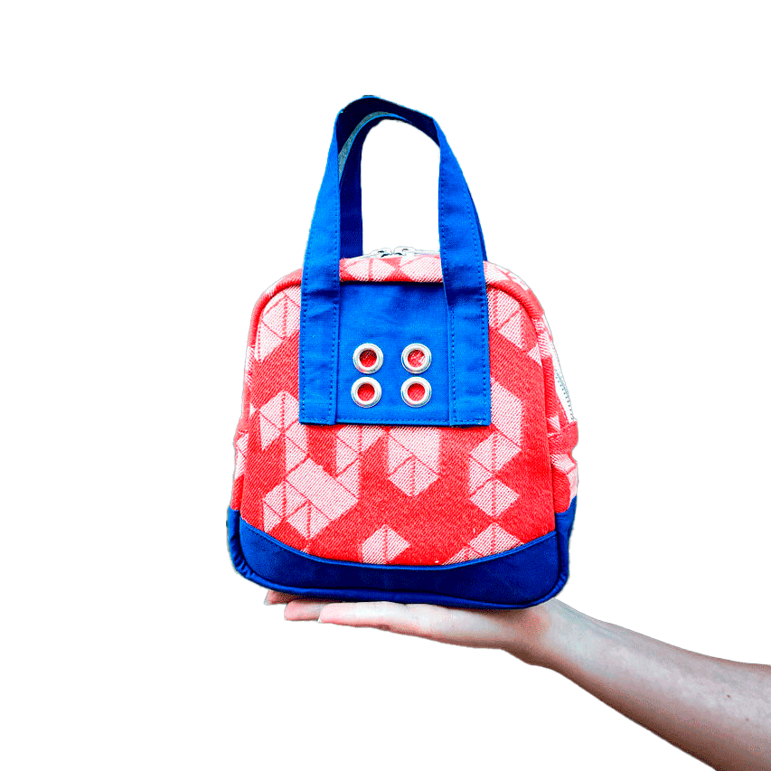 Un mini sac à main constitué de tissu d'écharpe orange au motif géométrique blanc, et de toile de bleu de travail bleu Klein.