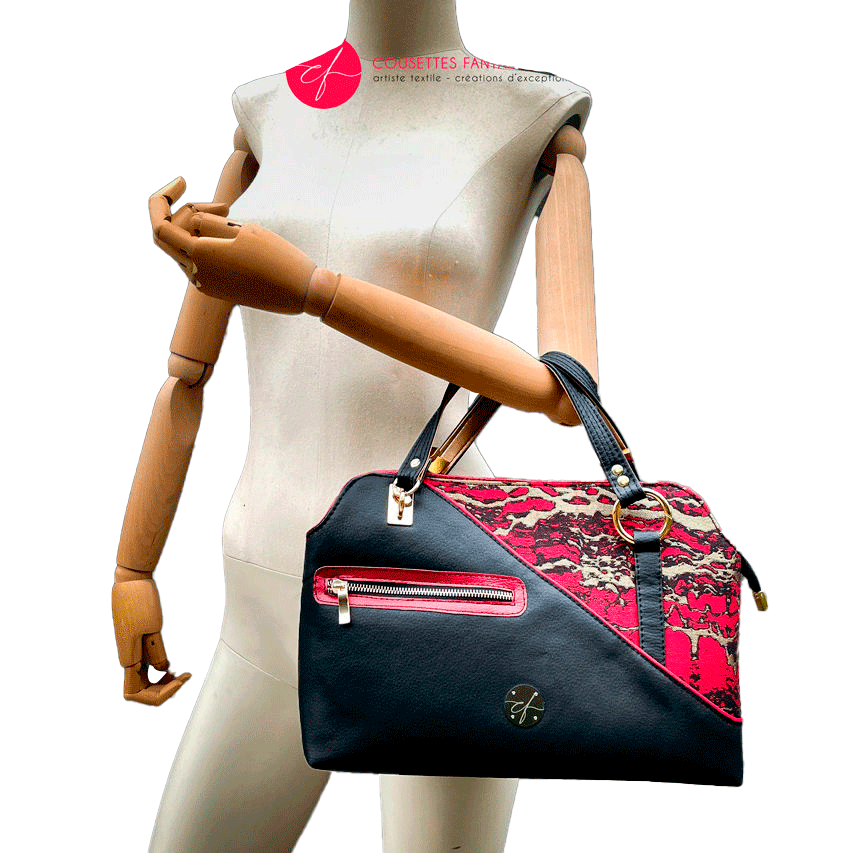Un sac d'épaule fait en similis noir, doré et rouge, et tissu d'écharpe dans les mêmes tons, motif marbré.
