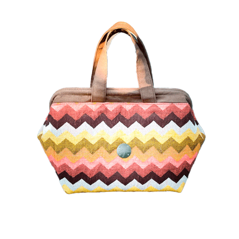 Un sac à main fait en tissu d'écharpe au motif chevron géant dans les tons d'automne (rose, marron, orange, jaune et blanc).