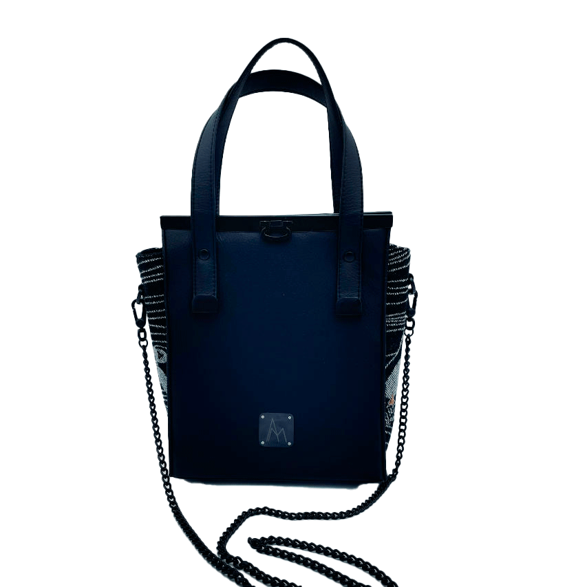 Un petit sac à main confectionné à partir d'écharpe de portage au motif de macareux dans des vagues stylisées dans des tons noirs, blancs et orange, et du simili noir.