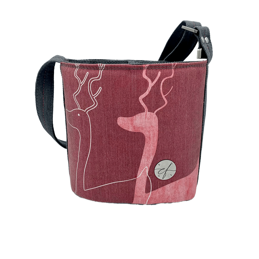 Un petit sac dit “seau” fait avec toile fine rose présentant deux silhouettes de cerfs blanches, et du denim haute-couture gris.
