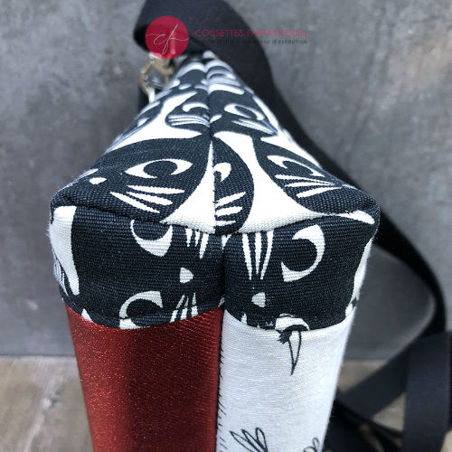 Un sac en bandoulière trapézoïdal fabriqué à partir de toile en coton noir et blanc avec des motifs stylisés de chats et d'oiseaux, assorti à de la cretonne de coton à thème aviaire à l'intérieur.