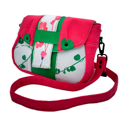 Un sac en bandoulière fabriqué à partir de néoprène aux motifs floraux, d'un crêpe rose fuschia et de cuir grainé vert vif.