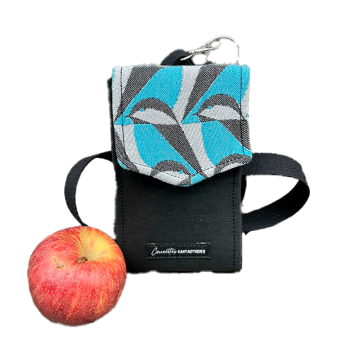 Un portefeuille-sac fabriqué à partir d'une écharpe de portage grise, noir et bleu ciel avec des motifs stylisés de tête de moineau, et du liège noir.