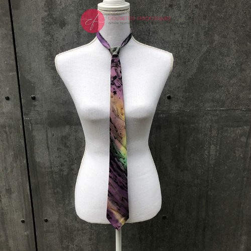Une cravate fine en mousseline de soie bleue, verte et violette, doublé de ramie taupe.