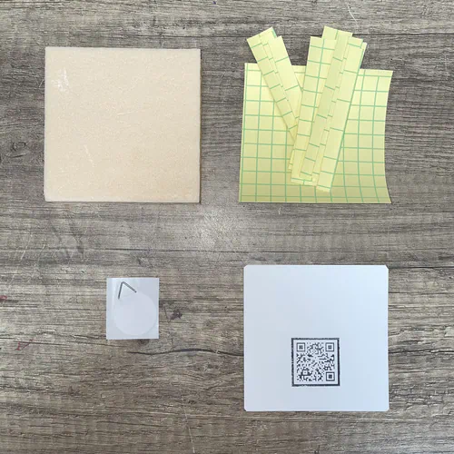 Le contenu de base du Kit Recharge Kinusaiga : sa plaque, ses adhésifs et le dos carton avec attache.