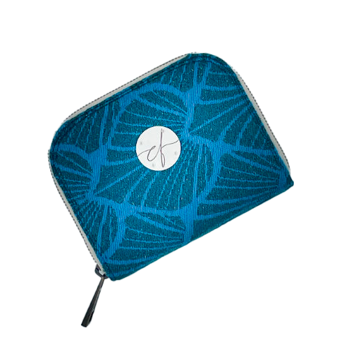 Un porte-cartes-et-monnaie zippé fabriqué avec un coupon d'écharpe de portage à motif de feuilles vert forêt et turquoise avec des paillettes.