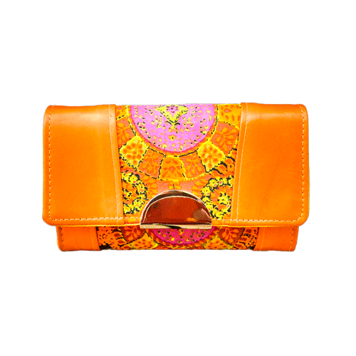 Un portefeuille fabriqué en cuir d'agneau orange et en tissu vintage multicolore en rayonne, dans des tons d'orange, de jaune et de rose.