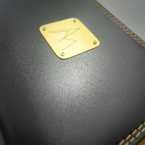 Un petit porte-cartes et porte-monnaie zippé en matériau à base de raisin, de couleur noir satiné et comme pailleté, avec une doublure rouge irisé de reflets violines et une popeline au motif floral en noir et blanc.