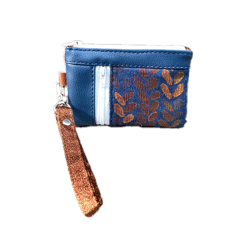 Un mini porte-monnaie zippé composé d'un patchwork de différents matériaux : simili bleu royal, simili doré, tissu bronze brillant et tissu d'écharpe de portage bleu et bronze avec un motif de petites gouttes.