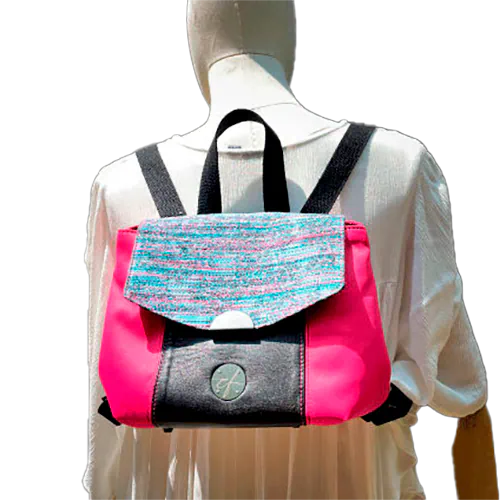 Un sac à dos fabriqué avec un tissu d'ameublement rose vif, du cuir noir et un coupon d'écharpe de portage au motif floral.
