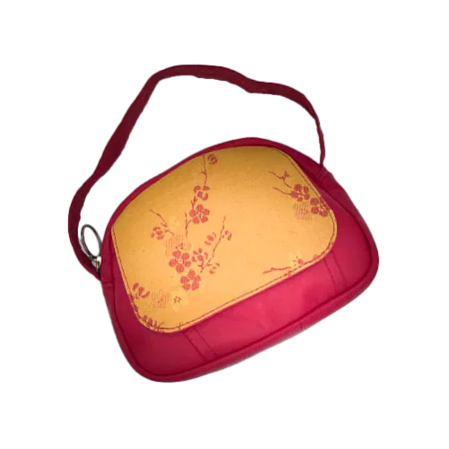 Un mini sac à main constitué de tissu d'ameublement jaune motif fleurs de cerisier rouge et de cuir rouge.