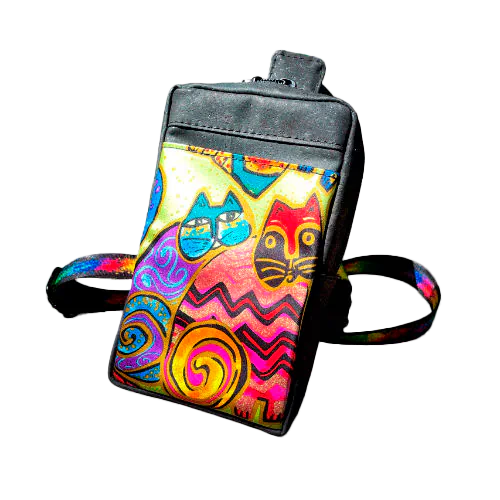 Un petit sac à dos cousu en liège noir mat et écharpe en soie avec un motif coloré de chats, associé à une sangle noire et arc-en-ciel.