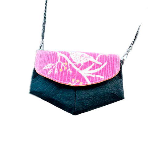 Une petite sacoche constituée d'un faux cuir noir à base d'ananas et d'un coupon d'écharpe rose, blanc et jaune.