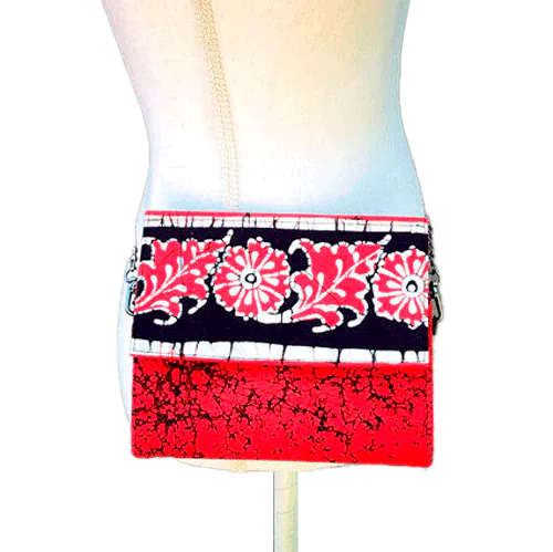 Un sac à main plat avec un rabat en tissu de coton batik noir, blanc et rouge.