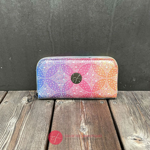 A zippered card and coin holder made with rainbow gradient babywearing scarf with pointillist star motif and gray high-couture denim.