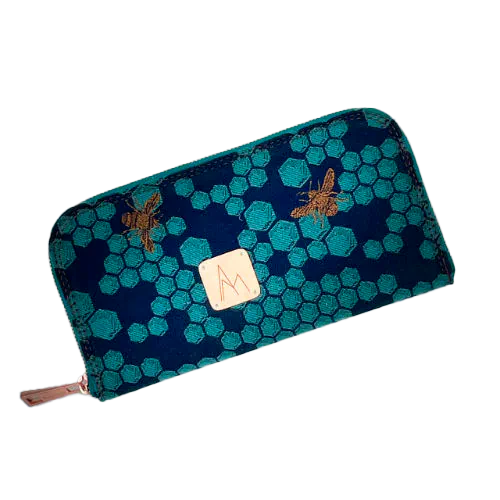 Un porte-cartes-et-monnaie zippé fabriqué à partir d'un coupon d'écharpe de portage bleu nuit et pétrole au motif de ruche et abeilles.