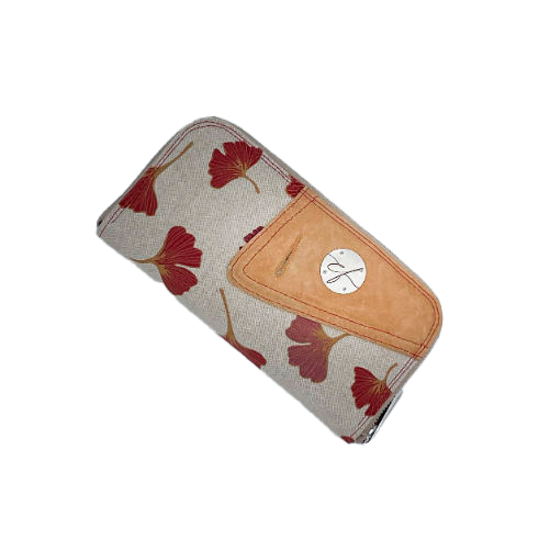 Un porte-cartes-et-monnaie zippé fait de cuir de couleur camel et d'une toile en polycoton avec un motif de feuilles de Ginkgo Biloba rouges.