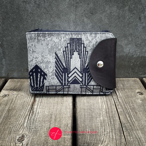 A wallet made from a midnight blue and silver geometric Art Deco patterned babywearing wrap, in midnight blue leather, midnight blue gabardine, and mouse gray poplin.