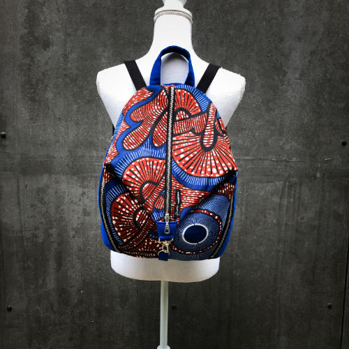 A backpack sewn with royal blue fabric and wax fabric in shades of blue, brown-red, black, and white.