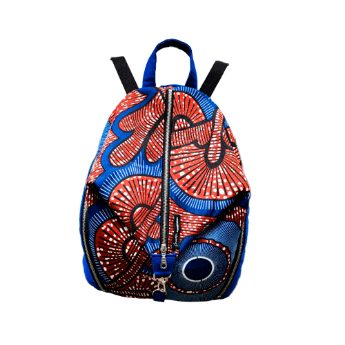 Un sac à dos cousu en toile bleu roi et tissu wax dans les tons bleus, marron-rouge, noir et blanc.