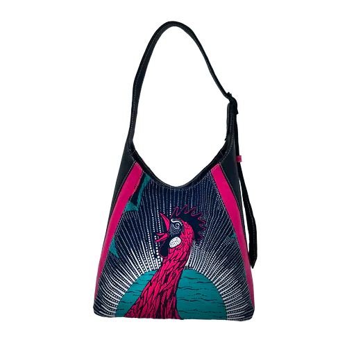 Un sac d'épaule fabriqué à partir d'un coupon de tissu façon wax et de chutes de cuir noir et rose, et doublé d'une doublure turquoise.