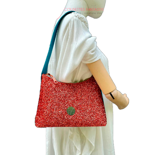 Un petit sac bandoulière zippé fabriqué à partir d'un tissu extensible avec du bouclé métallique cuivré, du simili bleu turquoise, et une doublure orange clair lumineuse.