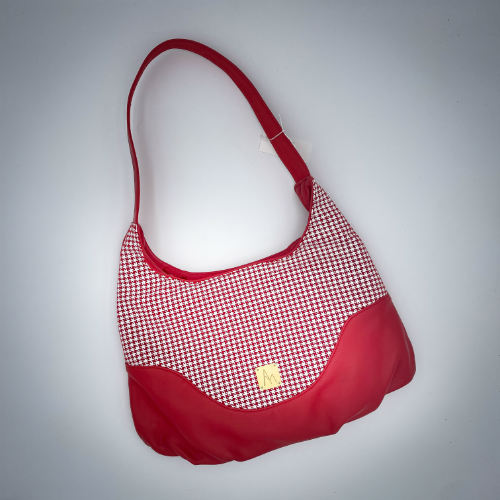 Un sac d'épaule fabriqué à partir d'un cuir rouge et d'un cuir rouge imprimée pied de poule blanc, avec une doublure rouge siglée Sonia Rykiel.