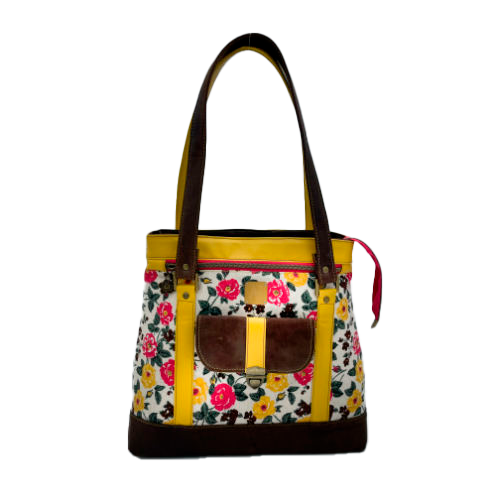 Un sac d'épaule fabriqué à partir de cuirs chocolat et jaune mariés à une toile fleurie avec des fleurs roses et jaunes.