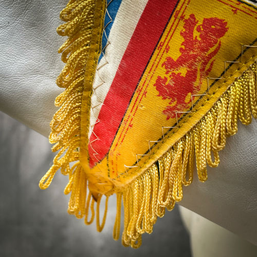 Un sac d'épaule composé de cuirs vert et blanc, d'un fanion vintage de sport et d'une doublure verte et blanche.